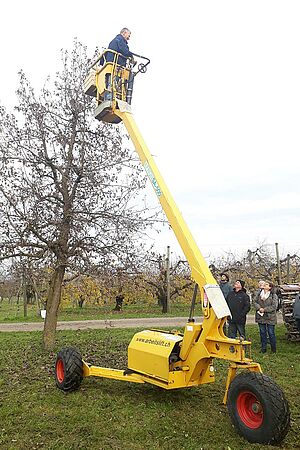 Photo: FiBL Un homme sur la plate-forme d'une échelle hydraulique à côté d'un arbre fruitier autes tiges